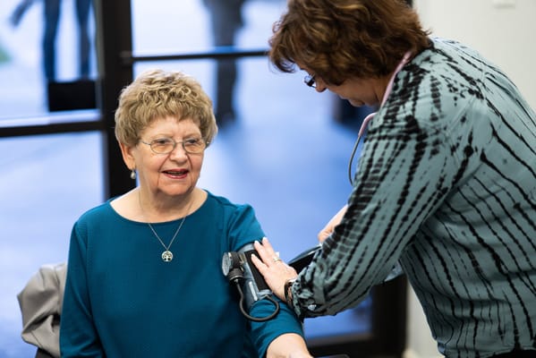 A resident receiving a health check-up from staff member