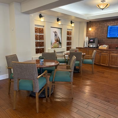 Common area with tables and chairs in a well-lit lounge