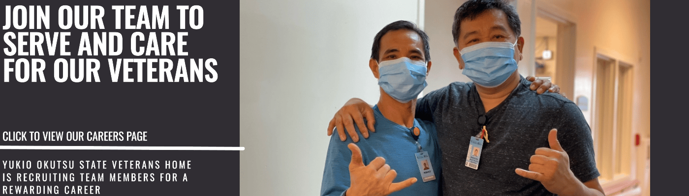 Two staff members posing together in a hallway
