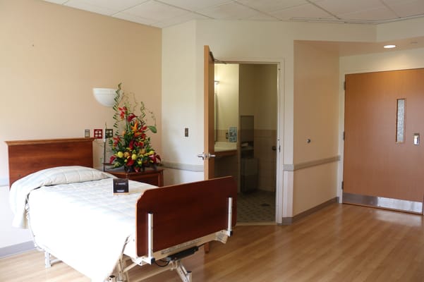 A spacious resident room with flowers and bathroom