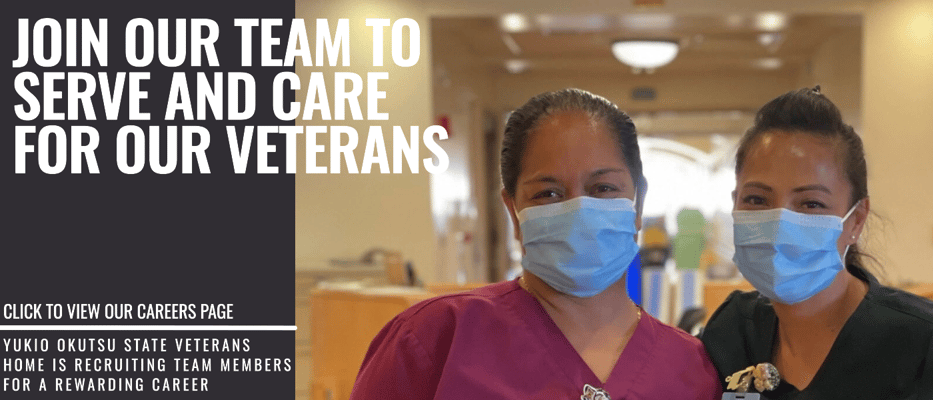 Two staff members in masks smiling in an interior space