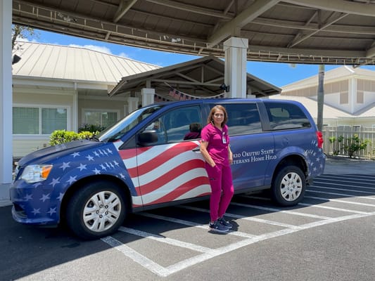 Staff member next to facility transport van.