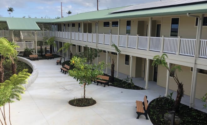 View of the courtyard surrounded by residential buildings with benches and greenery.