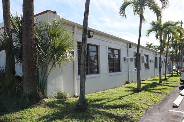 Side view of the nursing facility with palm trees and landscaping