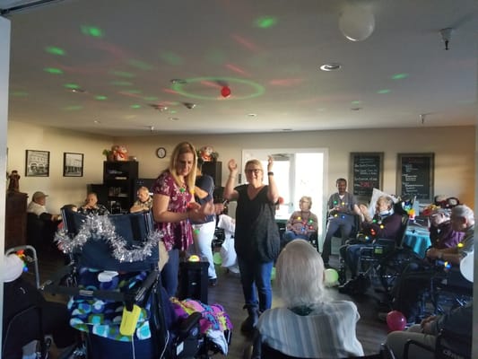 Residents enjoying a lively activity with staff in a common area