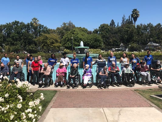 Residents and staff gathered by a fountain in a garden