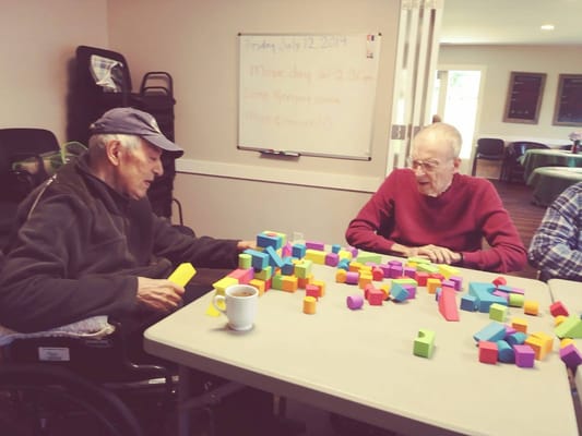 Residents engaging with colorful building blocks in a room