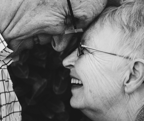 Close-up of two smiling seniors touching foreheads