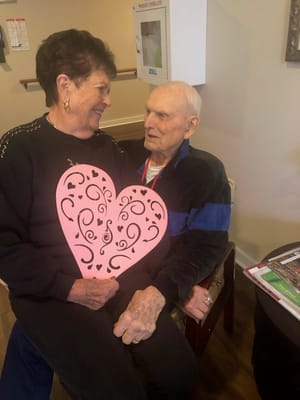 Residents celebrating with a heart cutout.