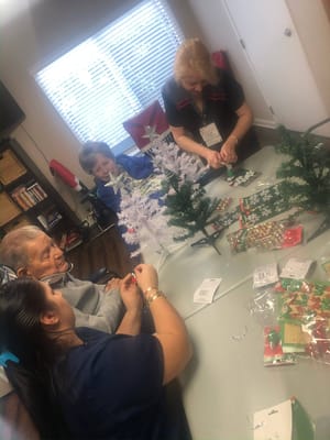 Residents and staff crafting decorations inside the facility