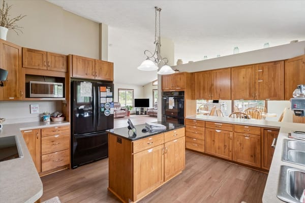 Bright kitchen area with wooden cabinets and appliances