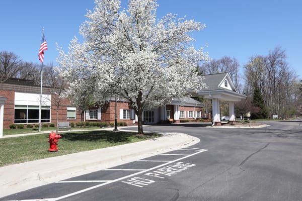 Exterior view of Woodhaven Retirement Community with blooming tree