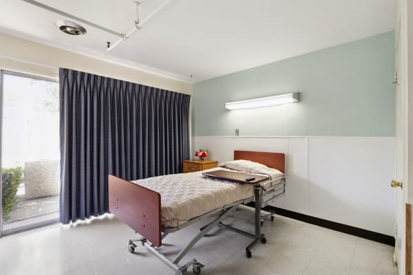 Private resident room with a bed and curtains