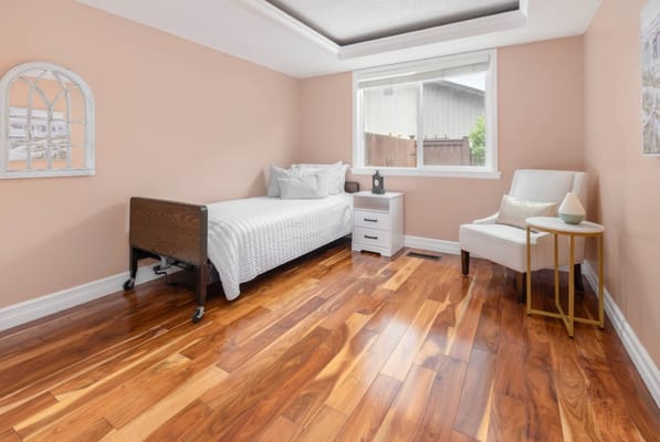 A well-furnished private resident room with wood flooring