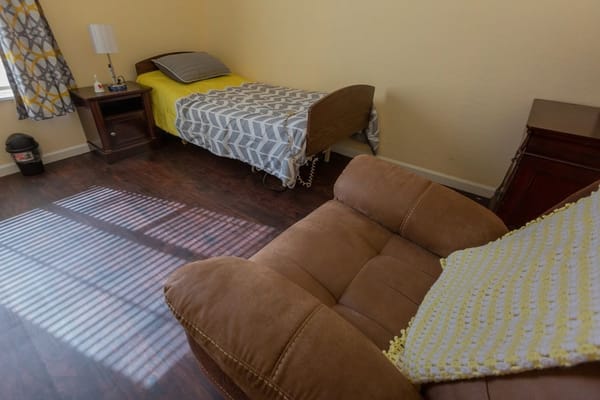 Private room with a bed and comfortable chair