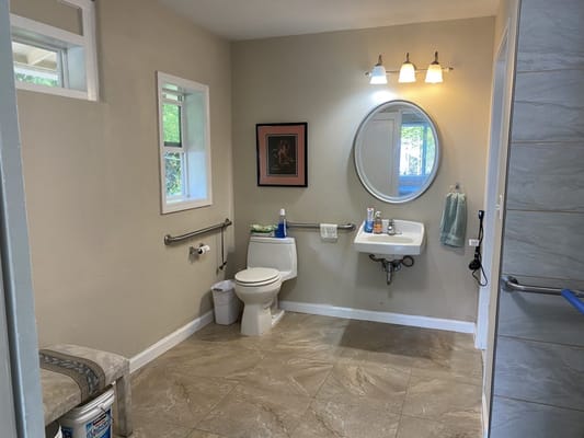 Well-lit bathroom with a toilet, sink, and wall mirror.