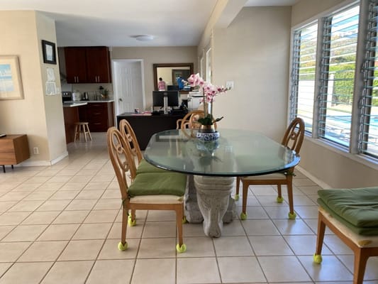 A dining table with chairs and an orchid centerpiece
