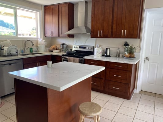 Contemporary kitchen with wooden cabinets and marble countertop.