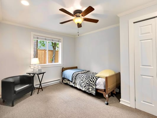 A well-lit private room with a bed and window
