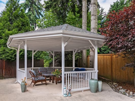 Outdoor gazebo seating area surrounded by greenery