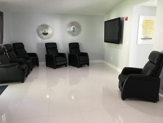 Interior waiting area with seating by a large screen