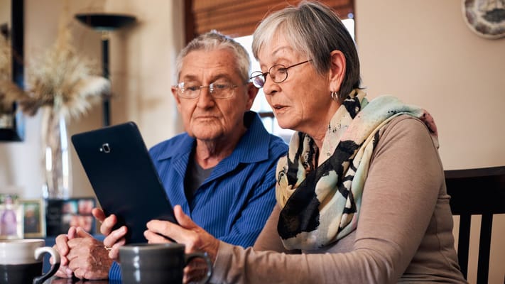 Senior couple using a tablet at a table