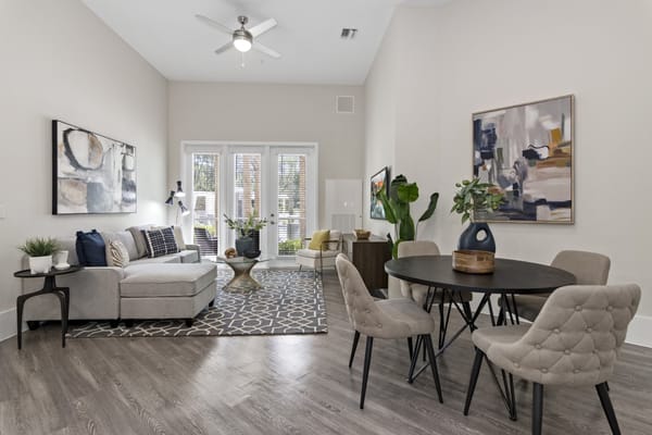 Modern living room with seating, dining table, and large windows