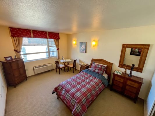 Cozy interior view of a resident room with a bed and table