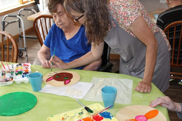 Resident and staff member engaged in an arts and crafts activity