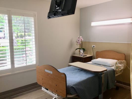 A private resident room with a hospital bed and window