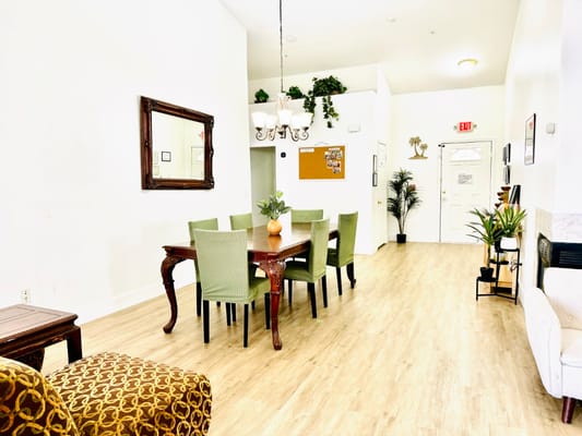 Bright common area with dining table and plants