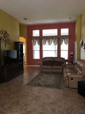 Spacious living room with a beige couch and television.