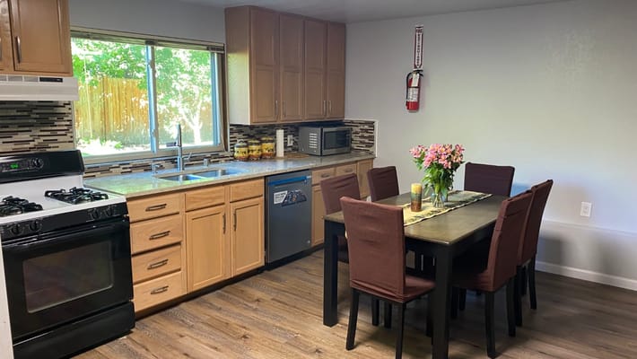 Bright kitchen area with a dining table and flowers