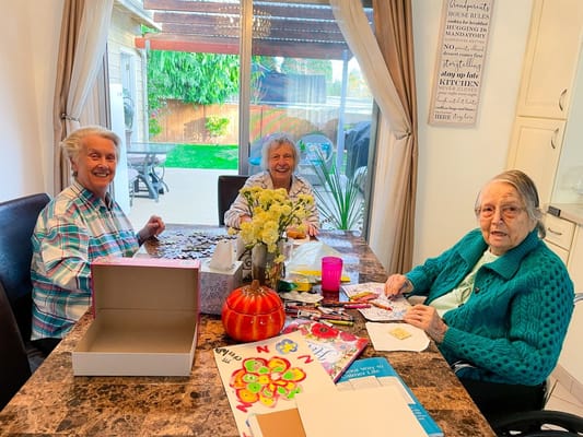 Three residents engaged in a crafting activity indoors