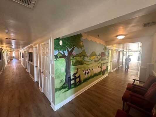 A hallway featuring a vibrant farm-themed mural with a person walking.