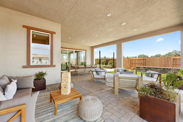 Outdoor lounge area with seating and a game on a patio
