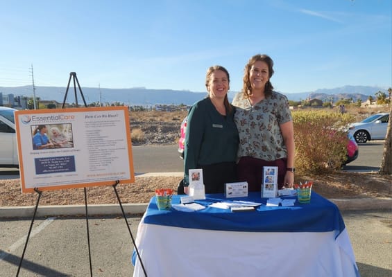 Staff members at an outdoor information table for Essential Care
