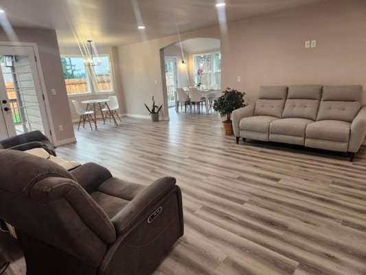 Spacious living room with gray sofas and dining area