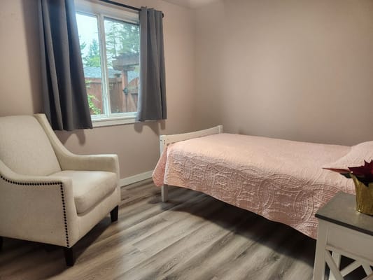 Cozy bedroom featuring a single bed and an armchair by the window