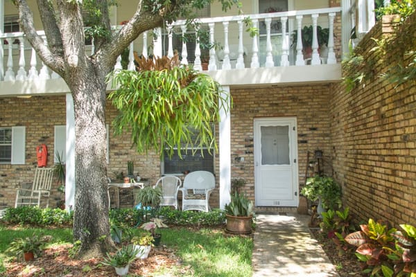 Entrance to a residence at Florida Living Retirement Community with lush greenery.