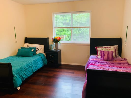 Cozy bedroom with two beds and a vase of flowers