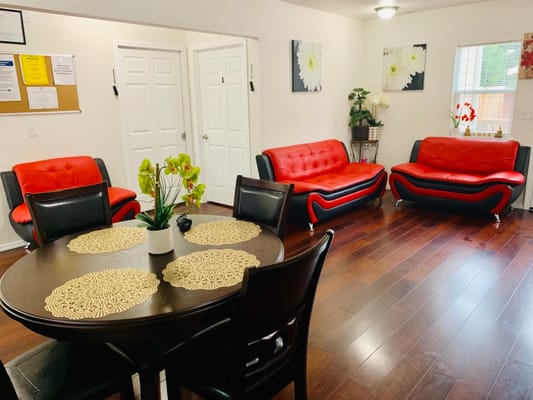 Bright common area with red sofas and dining table