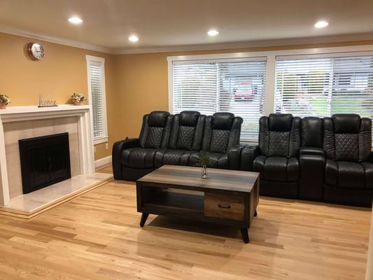 Spacious living room with black leather recliners and a coffee table