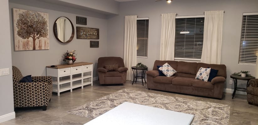 A comfortable living room with brown couches, decorative pillows, and a rug.