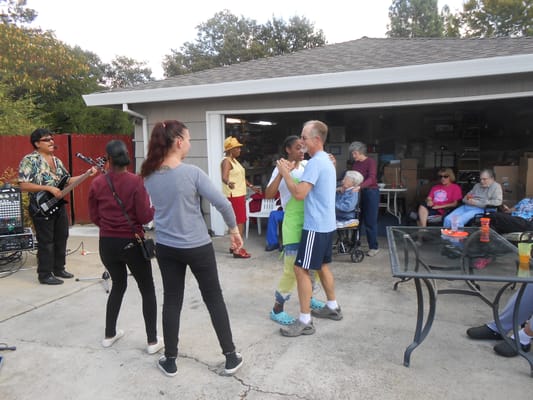 Residents and staff dancing outdoors during an event