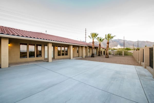 Outdoor view of a facility with palm trees and parking area