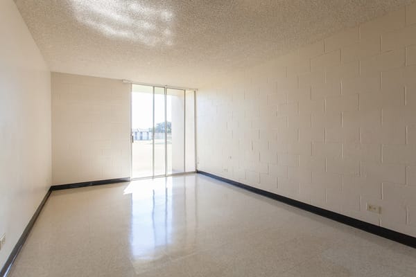 Spacious, sunlit living area with sliding glass door
