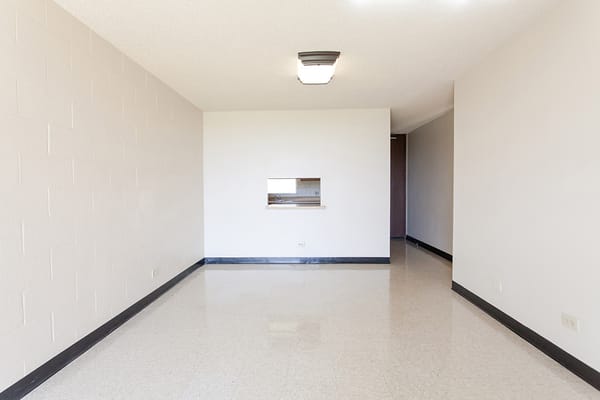 Empty living room with a view of the kitchen area