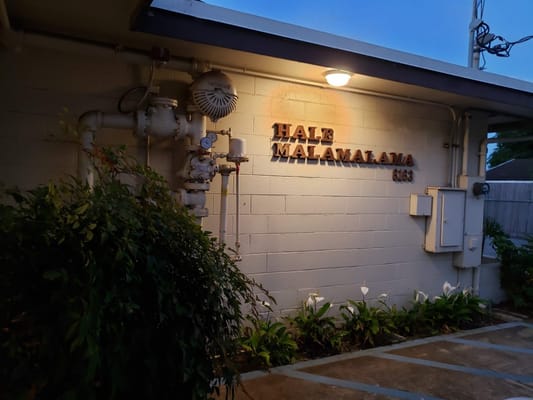 Sign of Hale Malamalama at dusk