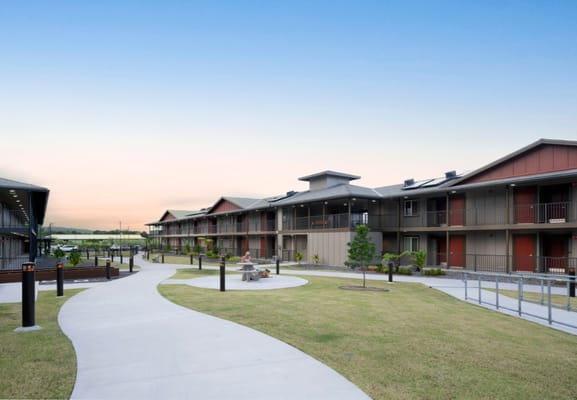 A smooth pathway with landscaped areas and buildings in the background